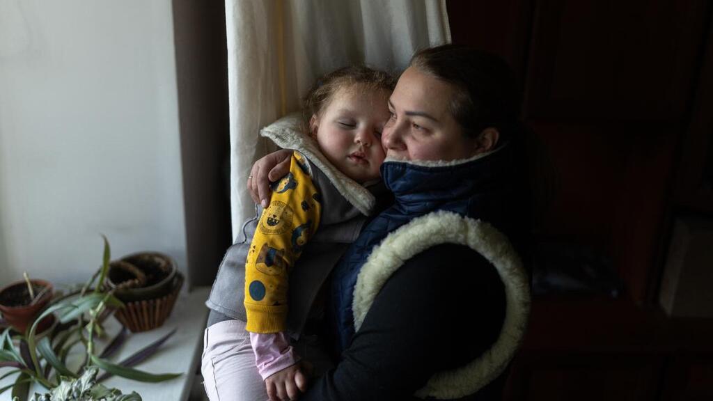 Ирина пытается согреть свою дочку Дашу: в квартире уже больше недели нет электричества.